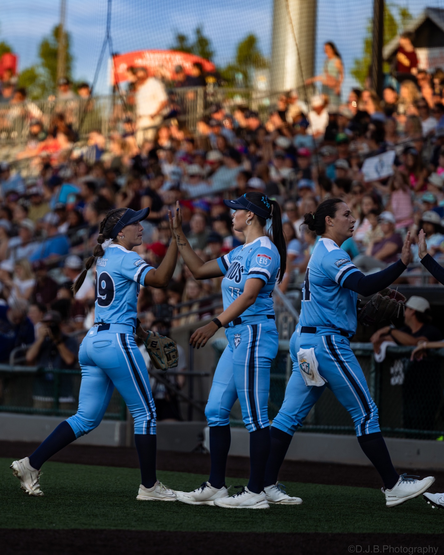 Kansas City Diamonds players exchanging high-fives beside the field
